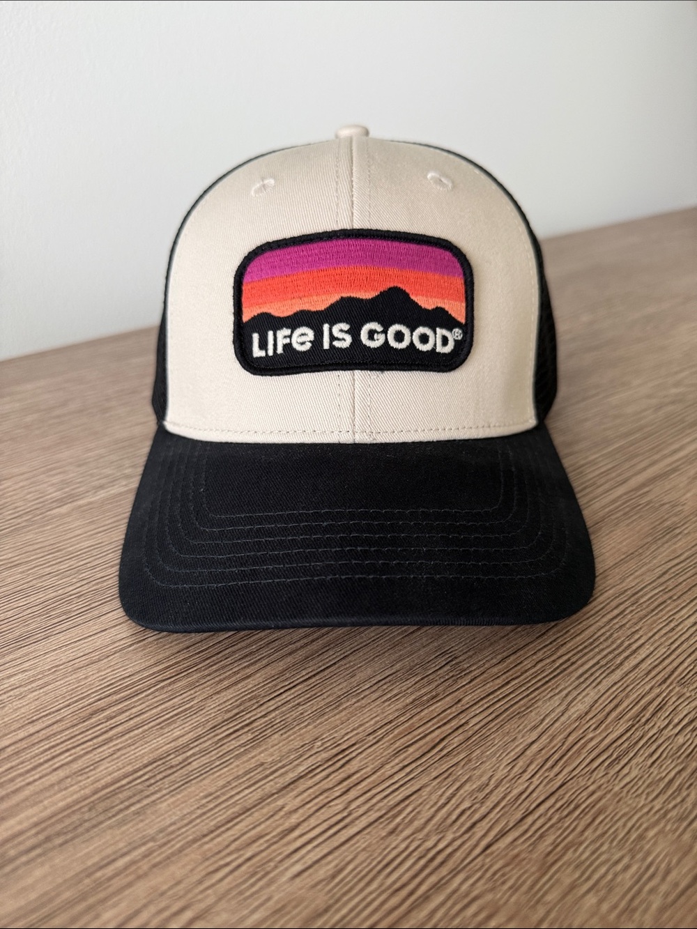 Life Is Good Cream Front Black Mesh Trucker Hat with Sunset Patch